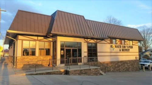 Exterior view of North End Tavern & Brewery, featuring a modern design with a metal roof and stone accents.