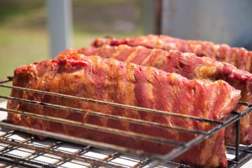 Close-up of juicy, grilled ribs on a barbecue grill, showcasing a rich, smoky glaze and appetizing texture.