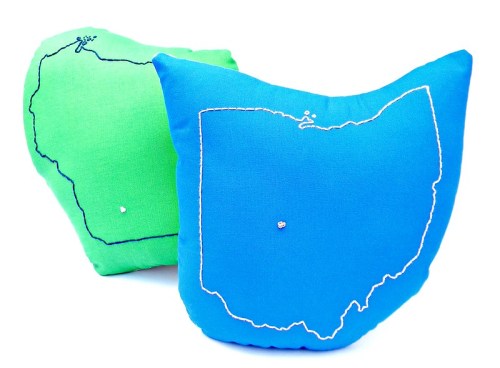Two colorful pillows shaped like the states of Ohio and Wisconsin, with embroidered outlines and small decorative details.