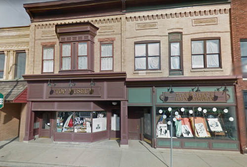 Historic storefronts featuring a shop called "Top Issue" and a business named "Maughey Place & Bakery Desserts."