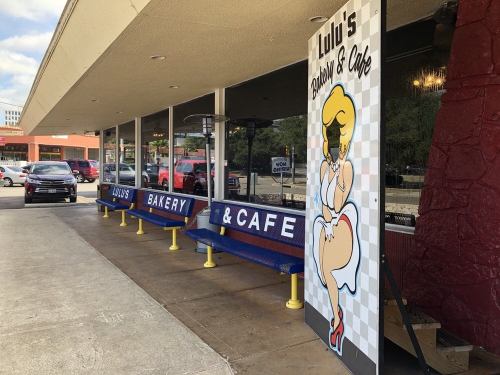 Exterior of Lulu's Bakery & Cafe, featuring colorful signage and outdoor seating along a sidewalk.