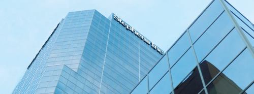 Modern glass building with a blue sky backdrop, featuring the name "Stephan Inc." prominently displayed.