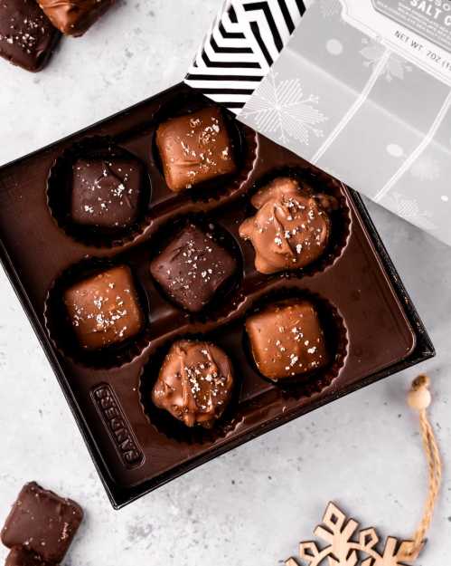 A box of assorted chocolates with a mix of dark and milk chocolate pieces, topped with sea salt.