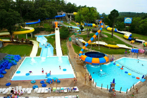 A vibrant water park featuring slides, pools, and visitors enjoying the attractions on a sunny day.