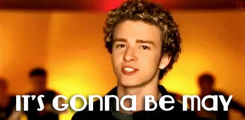 A young man with curly hair sings with enthusiasm, captioned "IT'S GONNA BE MAY" in bold letters.
