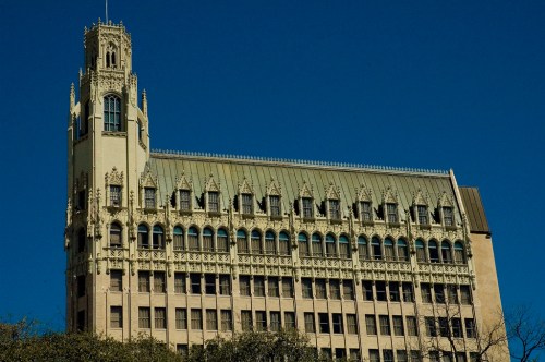 Historic building with ornate architecture and a tall tower against a clear blue sky.