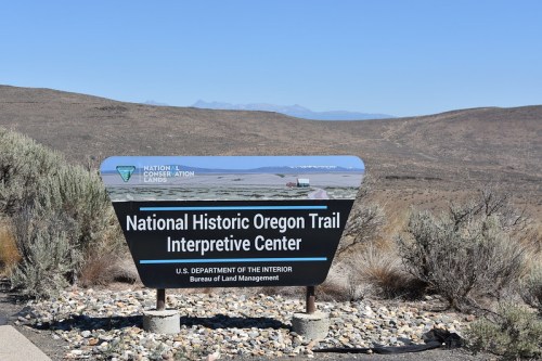 Sign for the National Historic Oregon Trail Interpretive Center, with a desert landscape in the background.