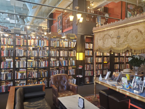 Cozy library interior with tall bookshelves, a vintage armchair, and a decorative table in a warm, inviting atmosphere.