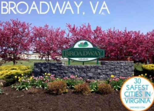 Welcome sign for Broadway, VA, surrounded by vibrant flowers and blooming trees.