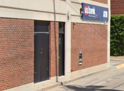 Exterior view of a US Bank ATM located on a brick building, with a clear blue sign above the entrance.