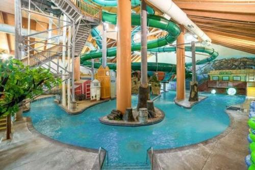 Indoor water park featuring a large pool, water slides, and tropical-themed decor.