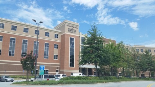 Exterior view of Gwinnett School of Mathematics, Science, and Technology, featuring a brick building and clear blue sky.