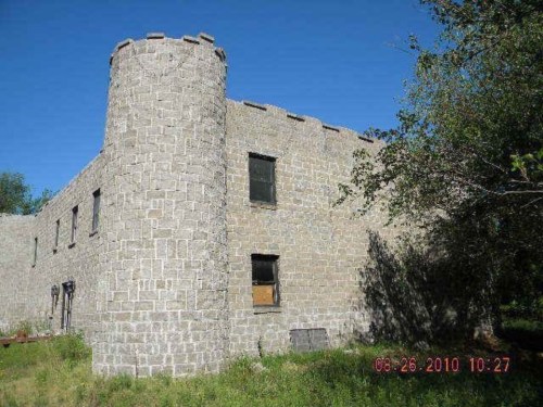 Stone building with a turret, surrounded by greenery under a clear blue sky. Date in the corner: 08-26-2010.