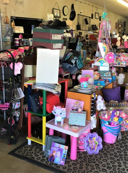 A colorful display of various items, including toys, shoes, and accessories, in a busy retail store.