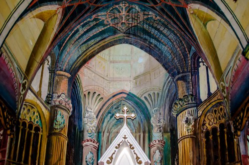 A colorful mural depicting a grand cathedral interior with intricate arches and a central cross.