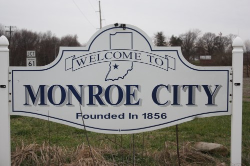 Welcome sign for Monroe City, Indiana, established in 1856, with a blue and white design.