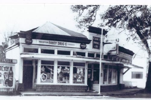 Black and white photo of Fahey Drug store, featuring a classic storefront with signage and large windows.