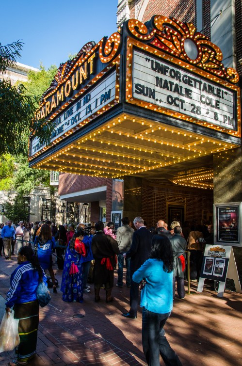 Crowd gathered outside the Paramount Theatre, with a marquee announcing a performance by Natalie Cole.