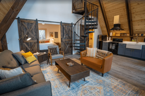 Cozy, modern living space with a spiral staircase, wooden beams, and a mix of comfortable furniture and decor.