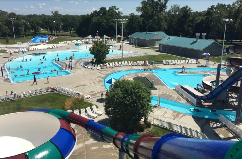 Aerial view of a water park with pools, slides, and people enjoying the sunny day.
