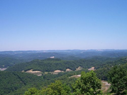 A panoramic view of rolling green hills under a clear blue sky.