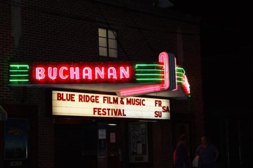 Neon-lit marquee of the Buchanan theater advertising the Blue Ridge Film & Music Festival. Nighttime setting.
