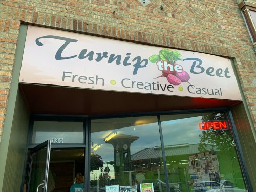 Sign for "Turnip the Beet" restaurant featuring the tagline "Fresh, Creative, Casual" with an open neon sign.