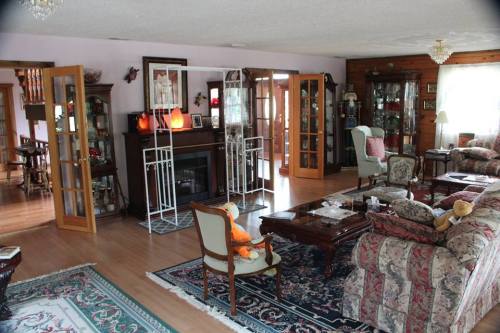 Cozy living room with patterned furniture, a fireplace, and glass doors leading to a dining area.