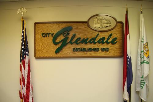 Sign for the City of Glendale, established 1912, with American and state flags on either side.