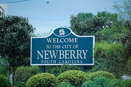 Welcome sign for Newberry, South Carolina, surrounded by greenery and trees.