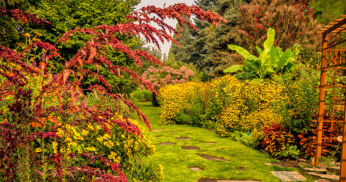 A vibrant garden path lined with colorful flowers and lush greenery, leading through a serene landscape.