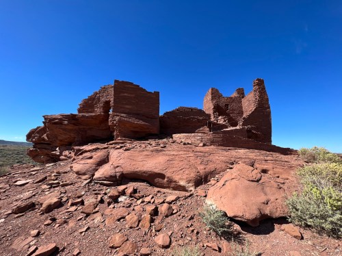 Ancient stone ruins on a rocky landscape under a clear blue sky.