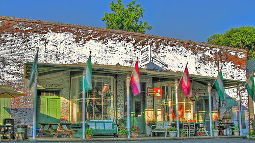 Historic building with colorful flags, featuring large windows and a sign that reads "Lone Star Studio."