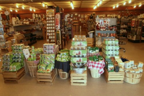 A cozy store interior filled with wooden crates of various packaged goods and kitchen items on display.