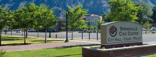 Sign for Springville Civic Center, featuring City Hall, Court, and Police, with trees and mountains in the background.