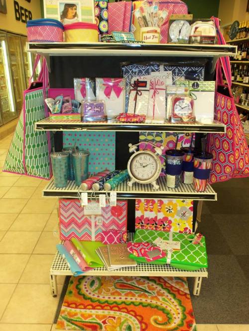 Colorful display of various patterned bags, stationery, and home decor items on shelves in a store.