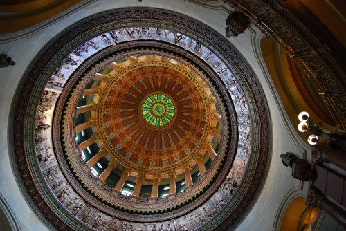 A stunning view of a circular dome with intricate patterns and colorful stained glass, showcasing architectural beauty.