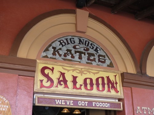 Sign for "Big Nose Kate's Saloon" with a colorful design, featuring the phrase "We've Got Food!" below.