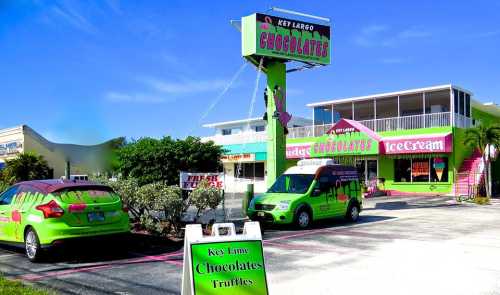 Brightly colored chocolate shop in Key Largo with green cars and a sign advertising chocolates and ice cream.