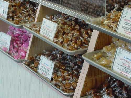 A display of assorted candies in clear wrappers, with labels indicating different flavors and types.