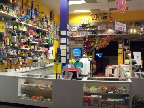 A colorful store interior filled with toys, snacks, and various merchandise displayed on shelves and counters.