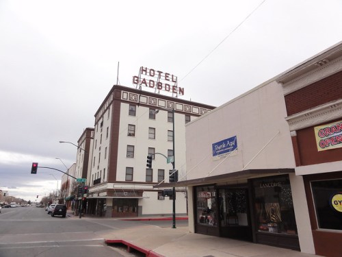 Historic Hotel Gadsden building with a neon sign, located on a city street with shops and traffic lights.