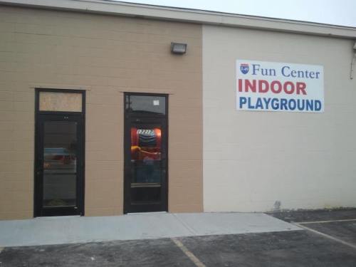 Exterior of a building with a sign that reads "Fun Center Indoor Playground" and two entrance doors.