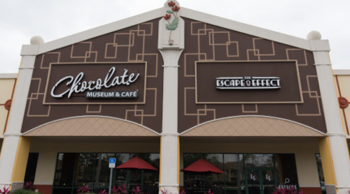 Exterior of the Chocolate Museum & Café, featuring a sign for The Escape Effect, with red umbrellas outside.