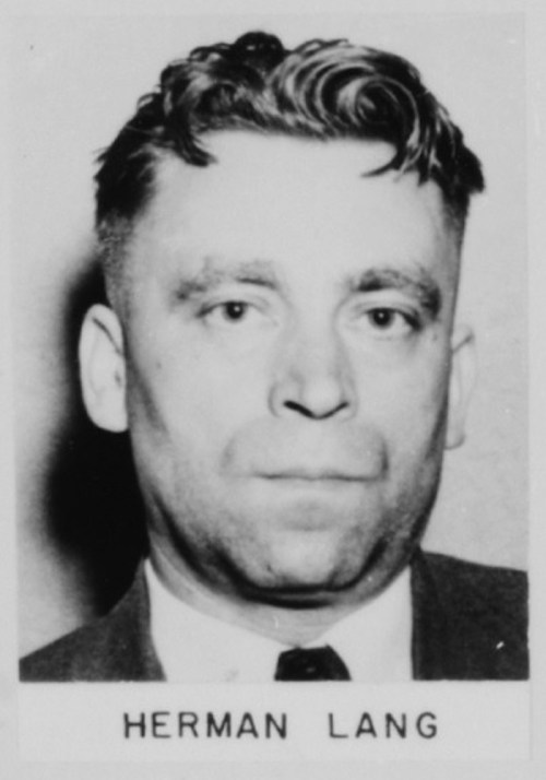 Black and white mugshot of a man with short hair, wearing a suit and tie, labeled "Herman Lang."