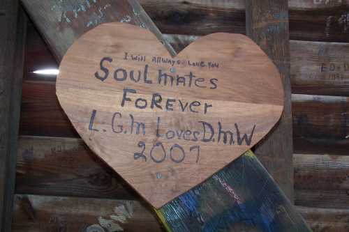 A wooden heart with the inscription "Soulmates Forever" and names L.G.M and D.H.W, dated 2007.