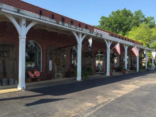 A charming storefront with wooden accents, featuring American flags and various decorative items outside.