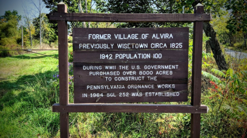 Sign marking the former village of Alvira, detailing its history and significance during WWII and the establishment of the ordnance works.
