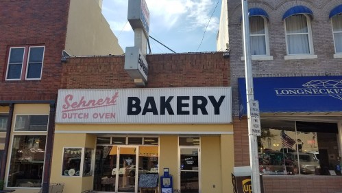 Sign for "Sehnert Dutch Oven Bakery" on a storefront, with a clear blue sky above.
