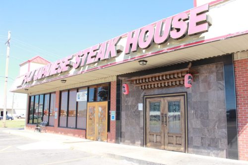 Exterior of a steakhouse with a large sign reading "Japanese Steak House" and decorative lanterns by the entrance.